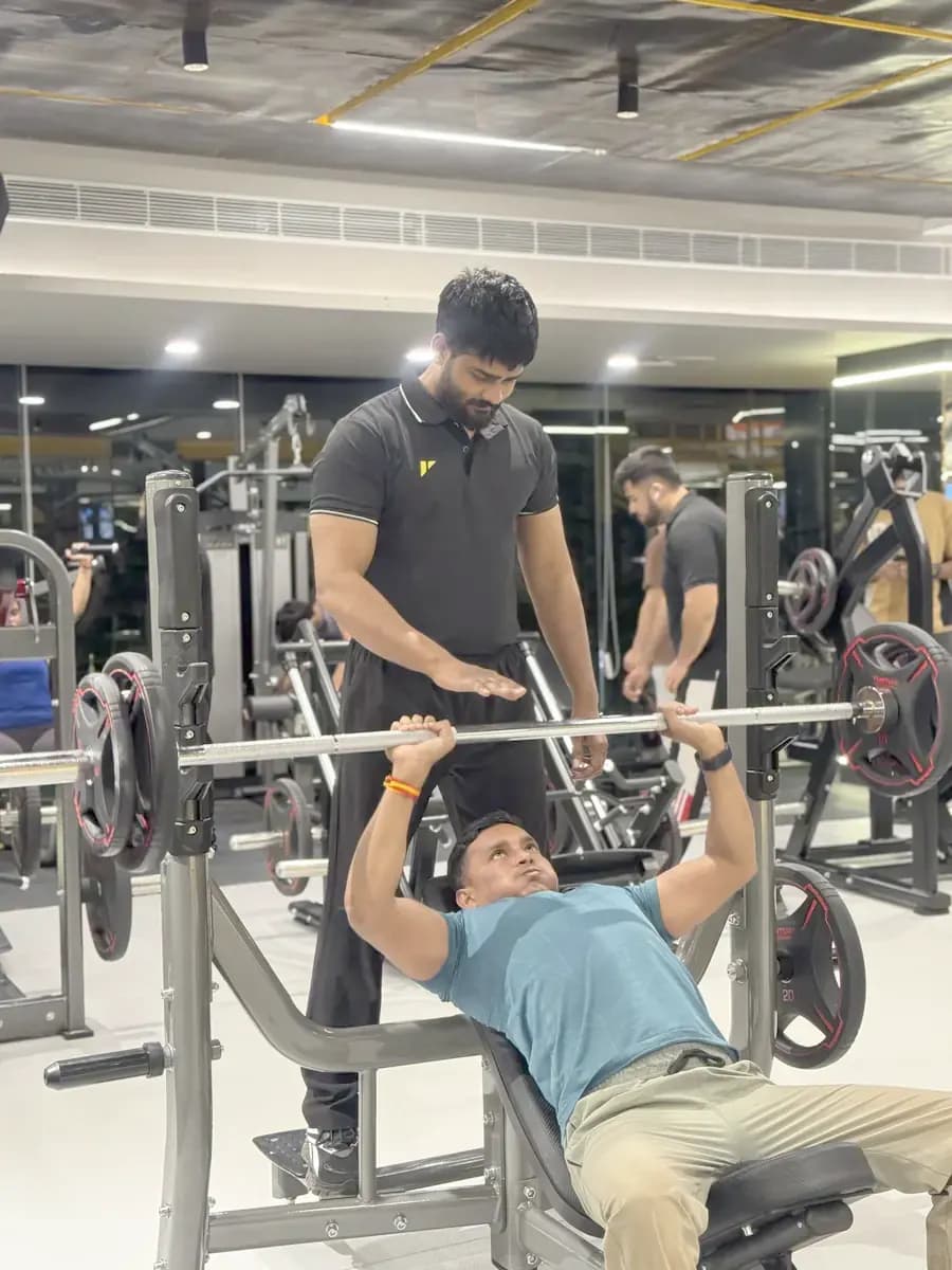 A trainer spotting a member on the bench press